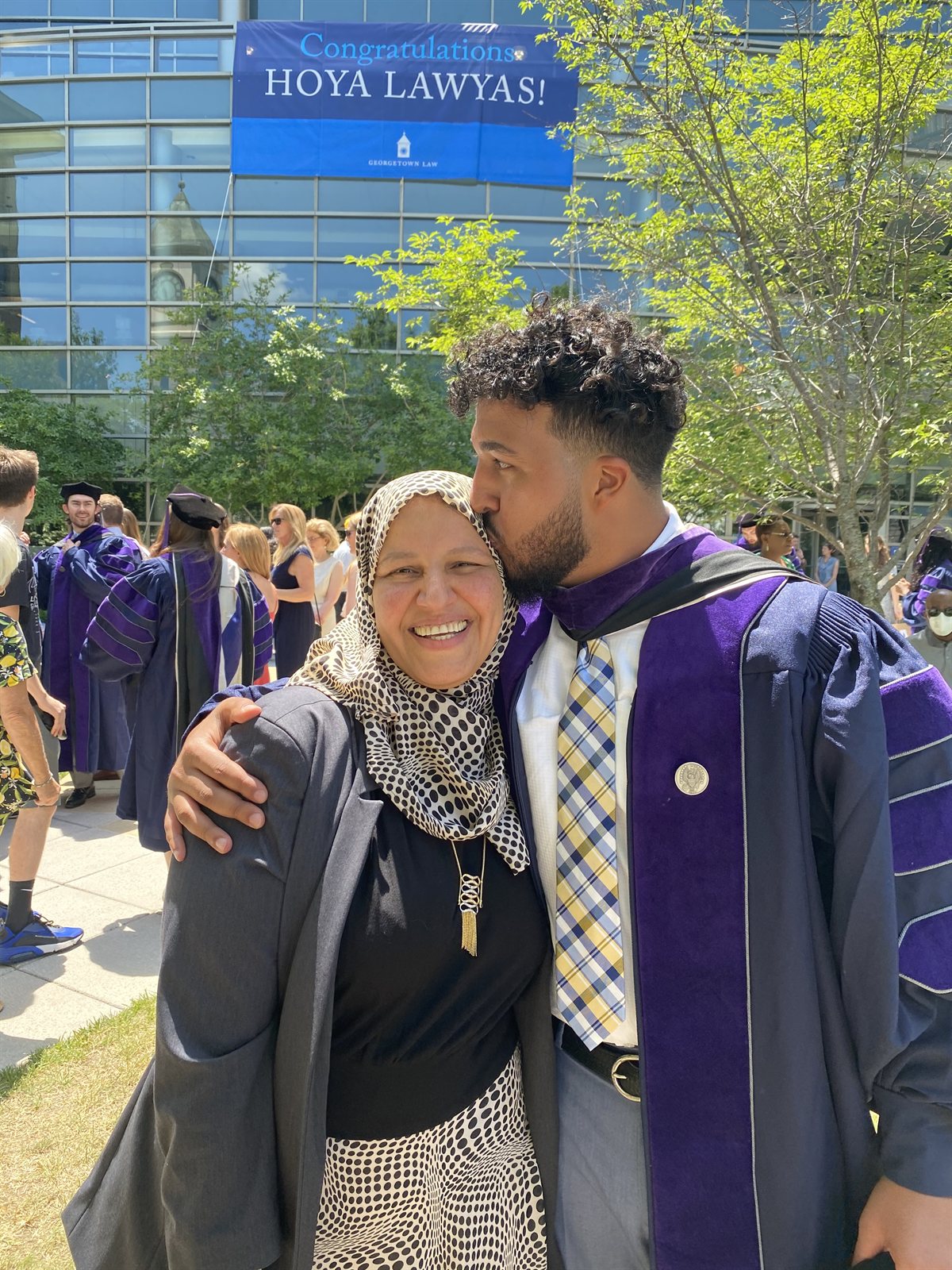 Ahmed kissing his mother on the forehead at Georgetown Law commencement